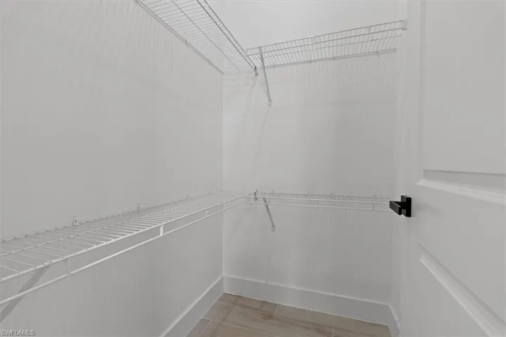 Walk-in closet with wire shelving and wood-finish tile flooring