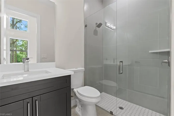 Contemporary bathroom featuring a dark wood-finish vanity with a white countertop and rectangular sink