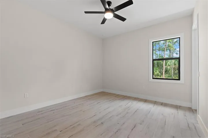 Wood-finish flooring, light-toned walls, and a contemporary ceiling fan