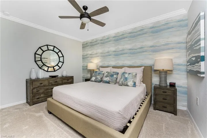 Bedroom featuring ornamental molding, a ceiling fan, carpet, wallpapered walls, and baseboards