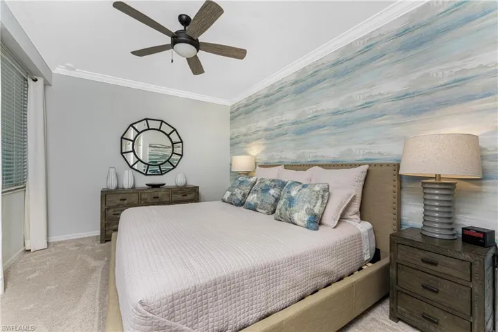 Bedroom with wallpapered walls, carpet flooring, baseboards, and ornamental molding