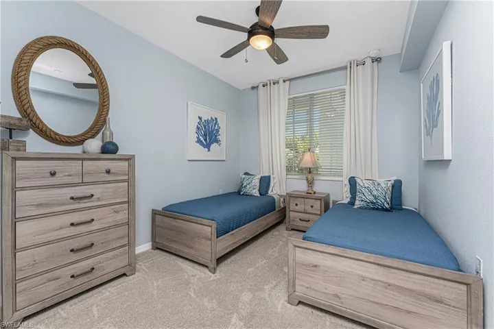 Bedroom featuring baseboards, light carpet, and ceiling fan