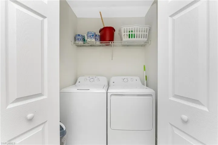 Clothes washing area featuring laundry area and washer and clothes dryer