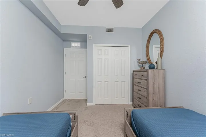 Carpeted bedroom featuring a closet, visible vents, a ceiling fan, and baseboards