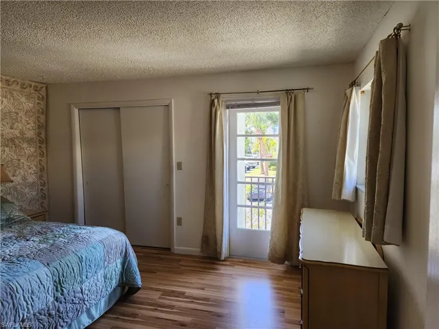 Bedroom featuring wood finished floors, a textured ceiling, and a closet