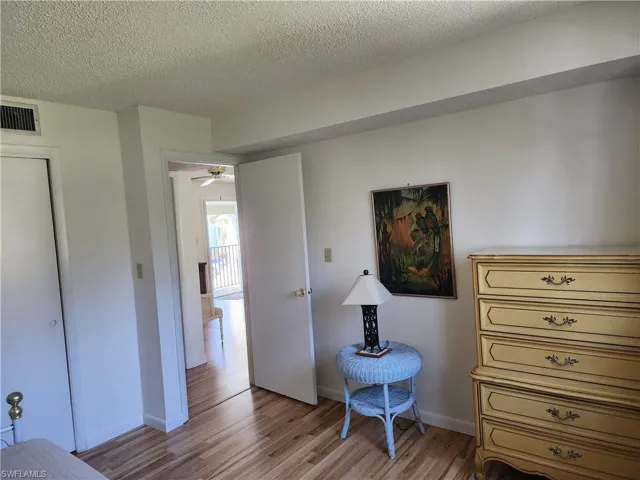 Sitting room featuring a textured ceiling, wood finished floors, and a ceiling fan