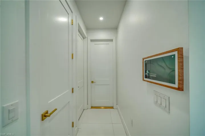 Hall with light tile patterned floors and recessed lighting
