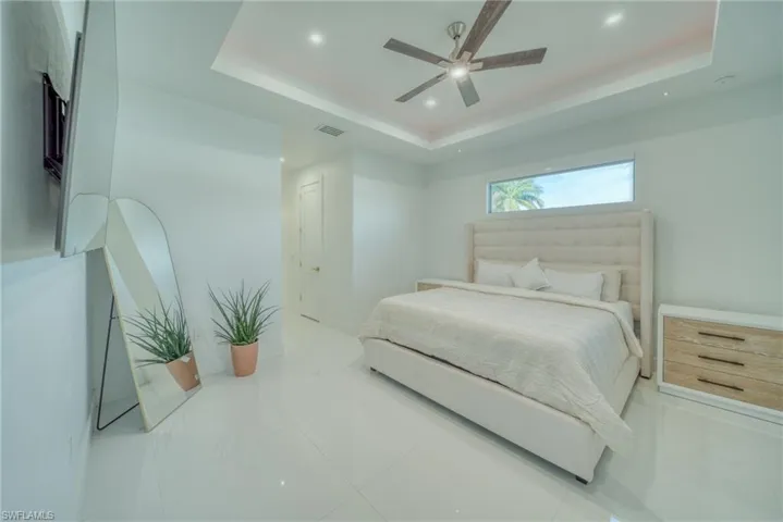 Bedroom featuring ceiling fan, a raised ceiling, and recessed lighting