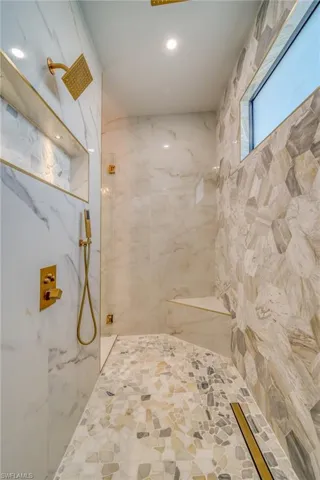 Bathroom featuring a marble finish shower and recessed lighting