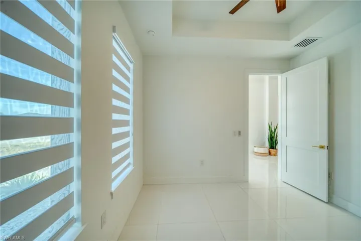 Spare room with a ceiling fan and light tile patterned floors