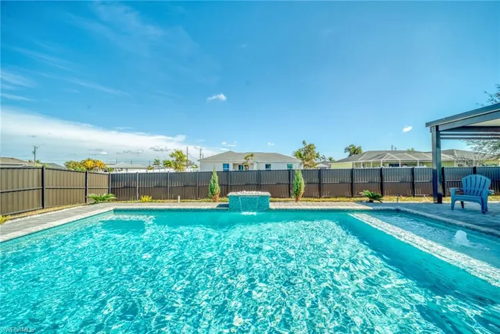 View of pool featuring a fenced backyard and patio surround