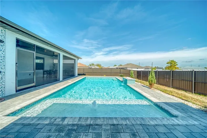 View of swimming pool with a sunroom, a fenced backyard, and patio surround