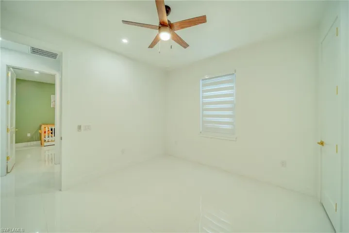 Empty room with a ceiling fan, recessed lighting, and light tile patterned floors