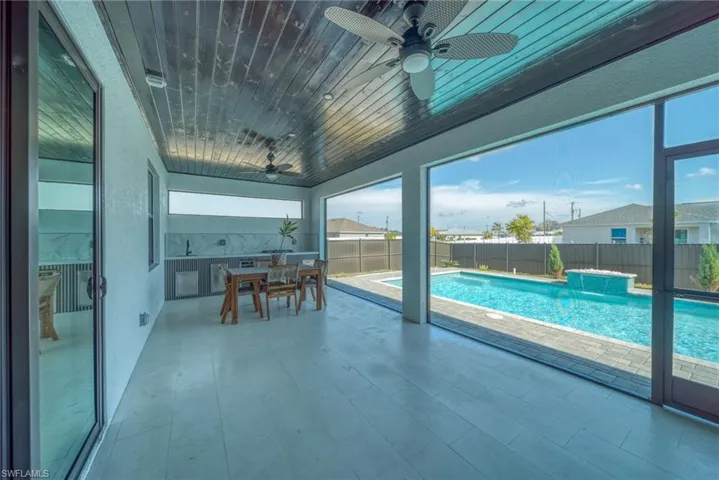 Sunroom featuring ceiling fan, outdoor dining space, and a patio