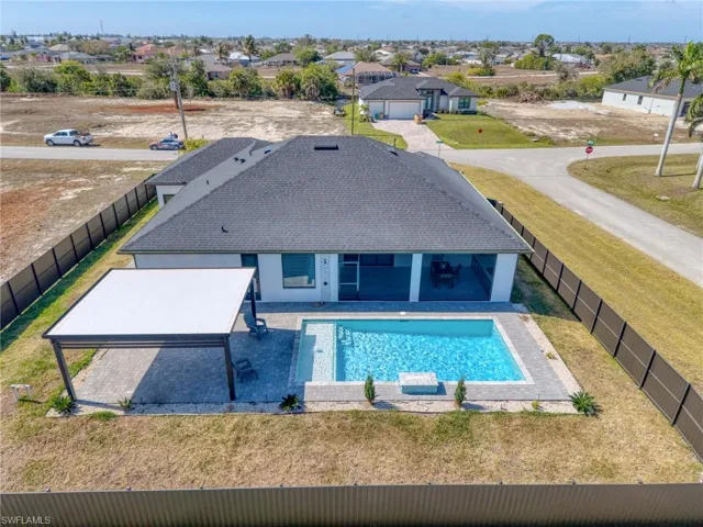 View of swimming pool featuring patio surround, a residential view, and a fenced backyard