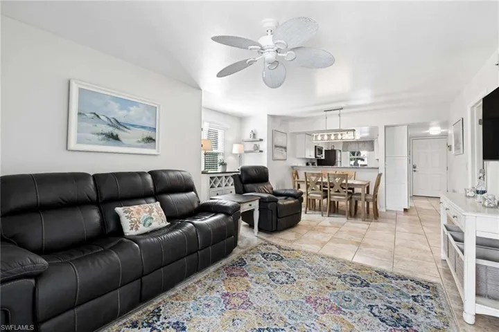 Neutral-toned tile flooring, ceiling fan with light fixture, built-in wine rack, and recessed lighting
