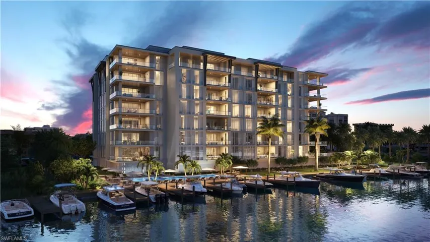 Property at dusk with a water view and a view of apartment building / complex