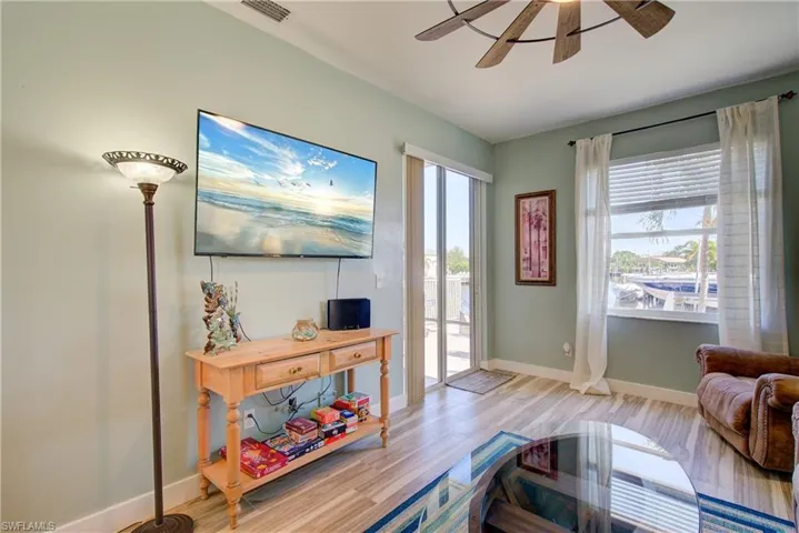 Living room with light wood-style flooring and ceiling fan
