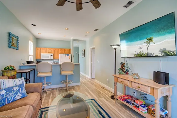 Living room with light wood-style flooring, recessed lighting, and a ceiling fan