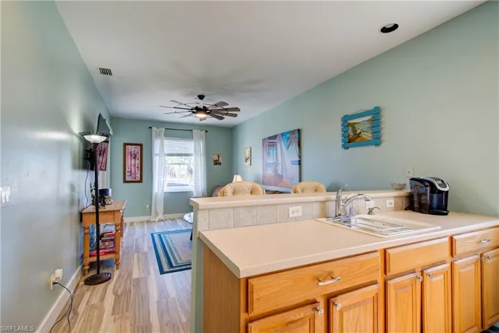 Kitchen featuring light countertops, light wood-style floors, a peninsula, open floor plan, and ceiling fan