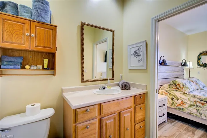 Bathroom featuring ensuite bath, vanity, and light wood-style floors