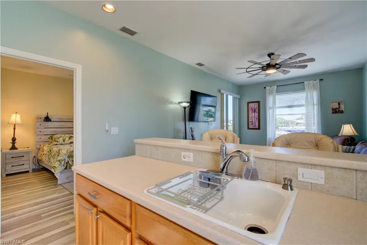Kitchen with light countertops, open floor plan, a ceiling fan, light brown cabinetry, and light wood-type flooring