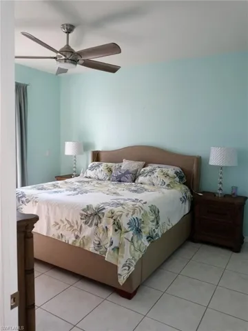 Bedroom with ceiling fan and tile patterned flooring