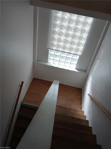 Stairway featuring wood finished floors