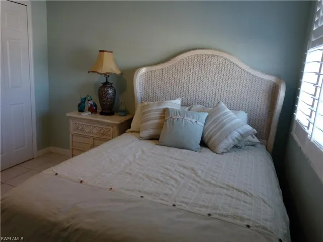 Bedroom with light tile patterned flooring and a closet