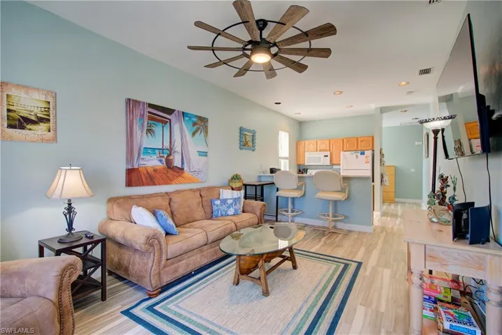 Living area with light wood finished floors, a ceiling fan, and recessed lighting