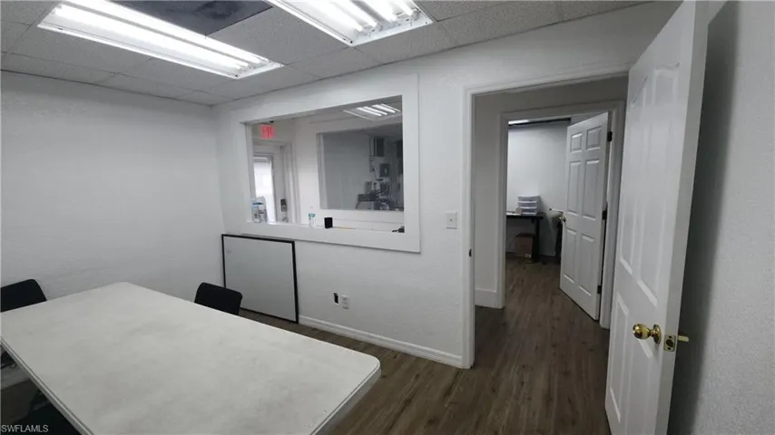 Office space with dark wood finished floors, baseboards, and a paneled ceiling