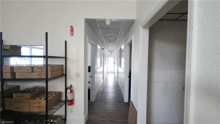 Corridor with healthy amount of natural light and wood finished floors