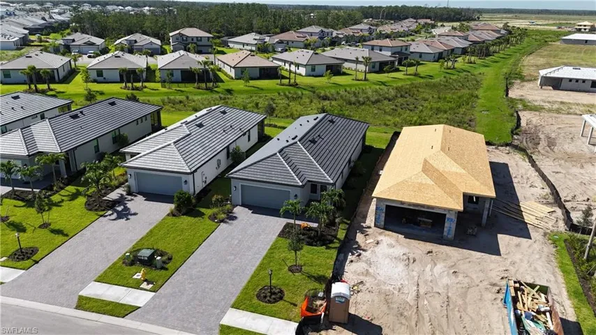 Modern residential development featuring newly constructed homes with tile roofs and paver driveways