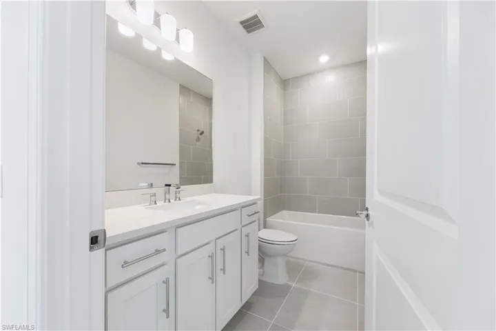 Bathroom featuring a white vanity with a light-toned countertop, a rectangular undermount sink, and a chrome faucet