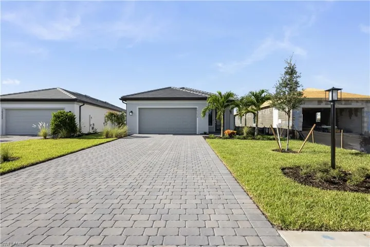 Paver driveway leading to a modern single-story residence with a two-car garage