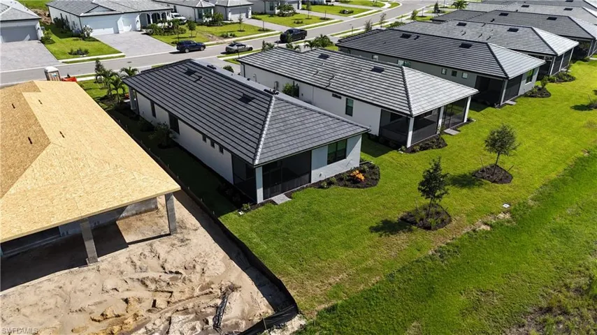 Newly constructed residence featuring a grey tile roof, white exterior siding, and a screened rear patio