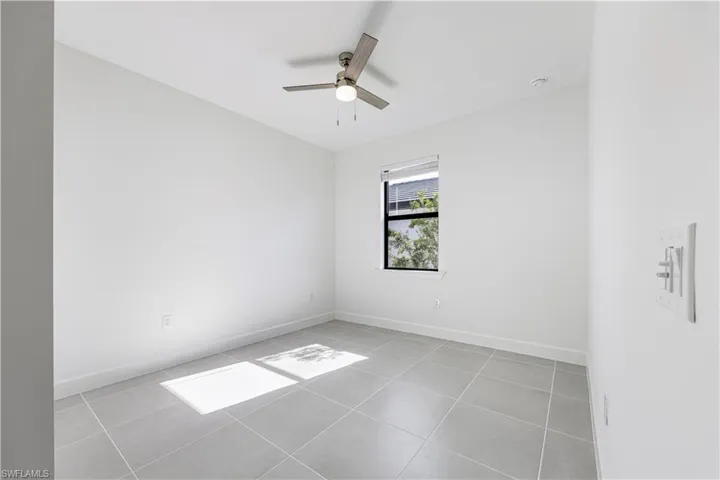 Room featuring ceramic tile flooring, a single window with blinds, a ceiling fan with integrated lighting, recessed lighting, and white baseboards