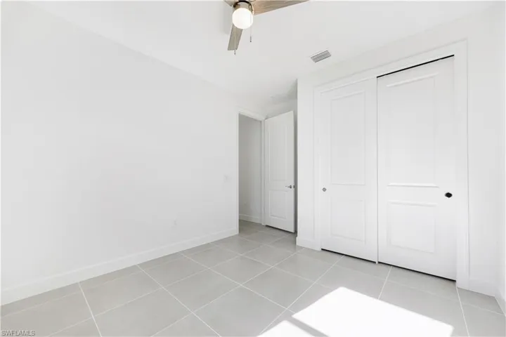 Spacious room featuring light gray tile flooring and white baseboards