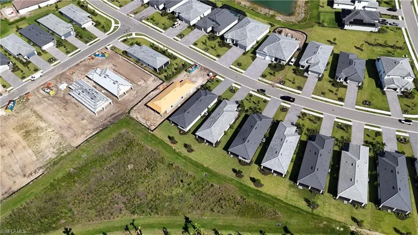 Aerial perspective showcasing a residential development with multiple single-story homes featuring light and dark gray shingle roofs