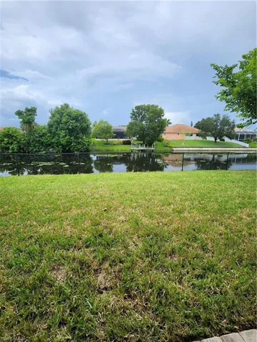 View of green lawn featuring a water view
