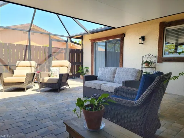 View of patio featuring glass enclosure and outdoor lounge area