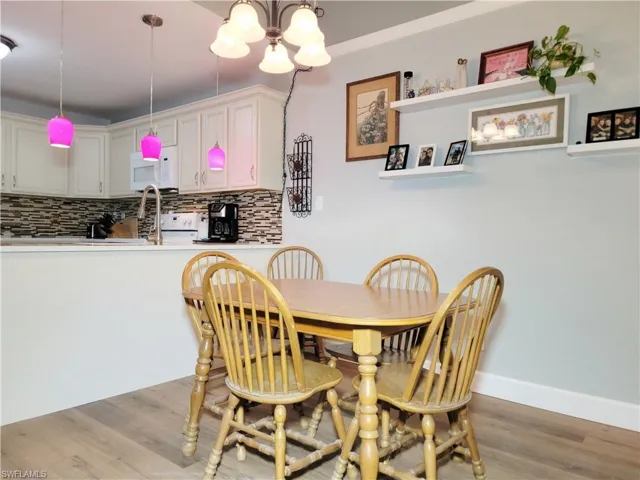 Dining area featuring an inviting chandelier, light wood-style flooring, and baseboards