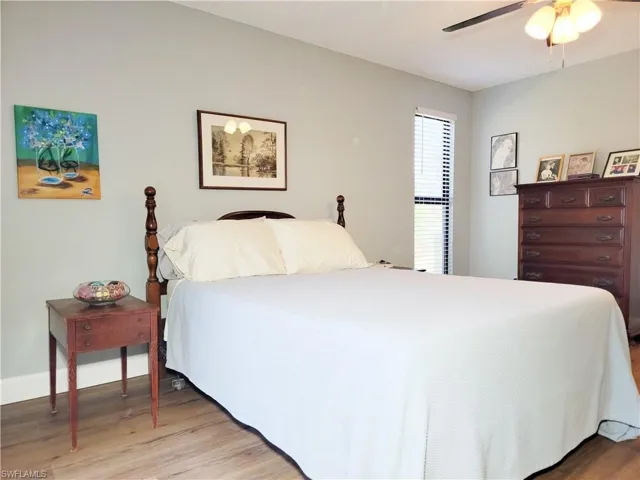 Bedroom featuring baseboards, light wood-type flooring, and a ceiling fan