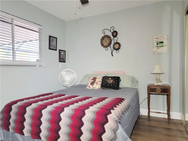 Bedroom with baseboards, a textured ceiling, and wood finished floors