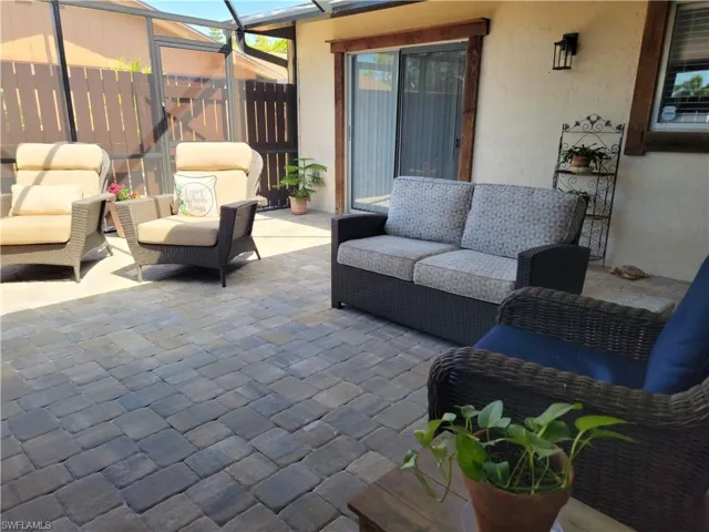 View of patio with glass enclosure and an outdoor hangout area