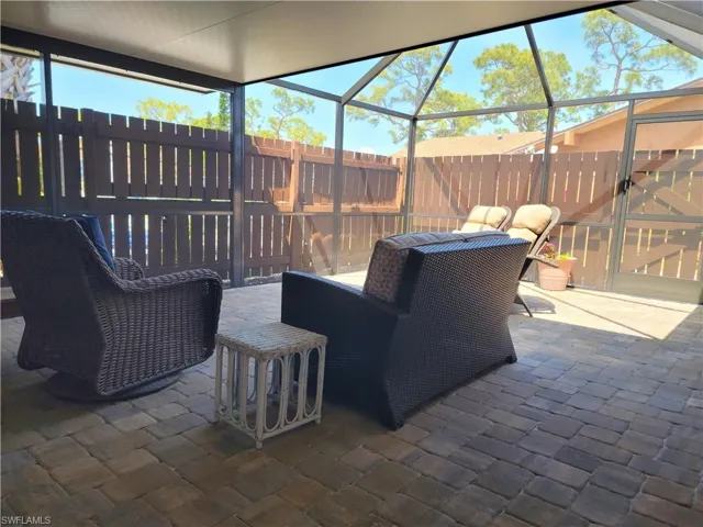 View of patio / terrace featuring glass enclosure and a fenced backyard