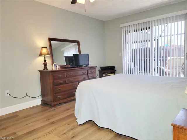 Bedroom with light wood-type flooring, baseboards, and a ceiling fan