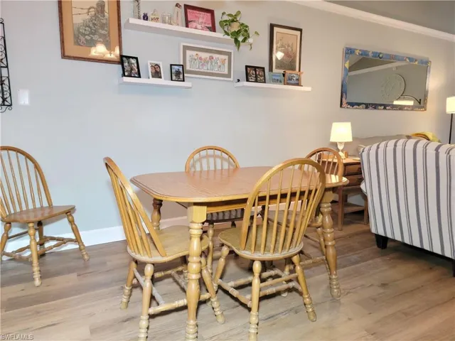 Dining area with crown molding, baseboards, and wood finished floors