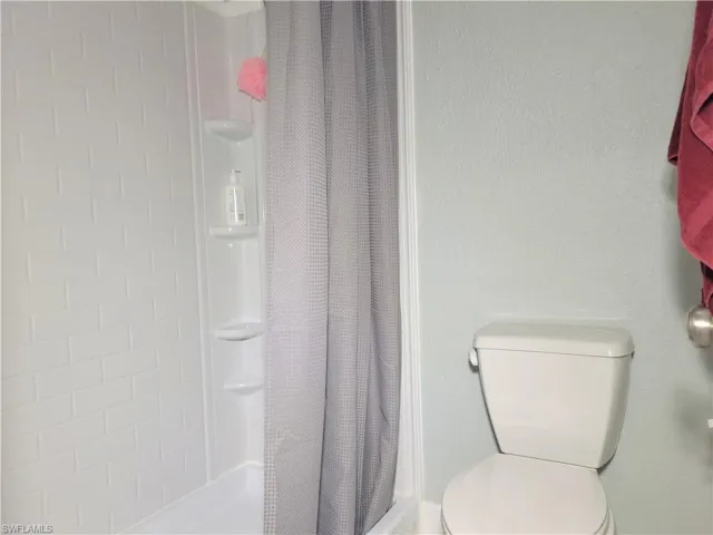 Bathroom with toilet and a shower with shower curtain