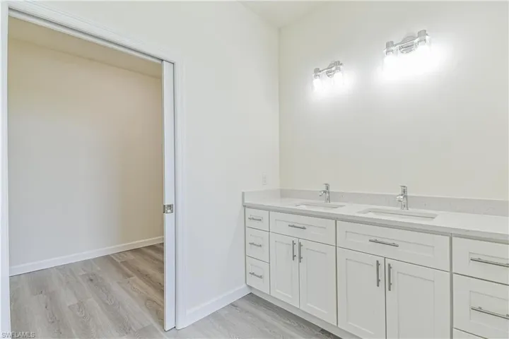 Bathroom featuring double vanity and light wood-style flooring